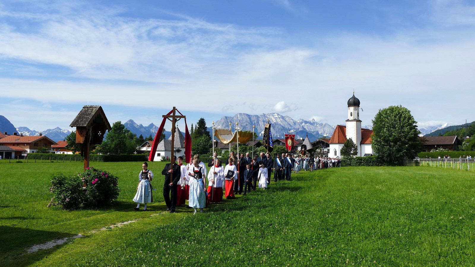 Fronleichnamsprozession in Wallgau. Im Hintergund Pfarrkirche St. Jakob und Wettersteingebirge.